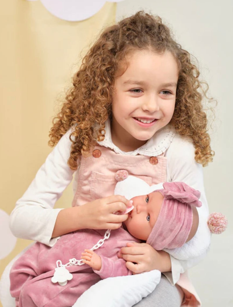 a girl plays with her llorens abril doll