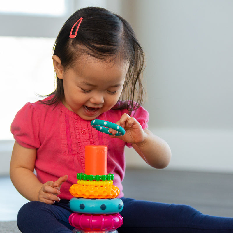 a child stacks the rings up on top of eachother