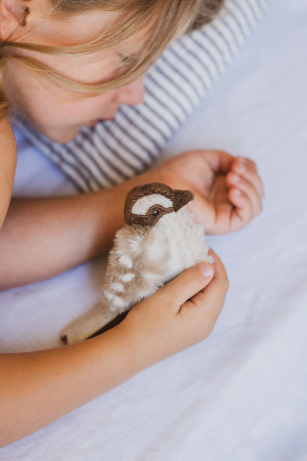 a child holds her kookaburra soft toy rattle